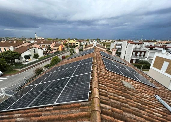 Impianto fotovoltaico su tetto a falde in coppi in un quartiere residenziale