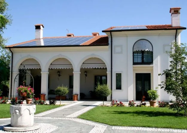 Impianto fotovoltaico realizzato da Zaia Serramenti sul tetto in coppi di una villa con portico ad archi